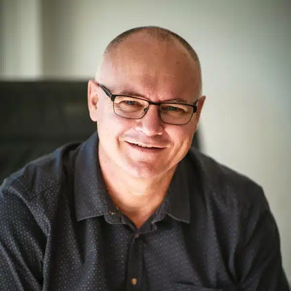 The About Us features a man smiling, wearing glasses and a black shirt.